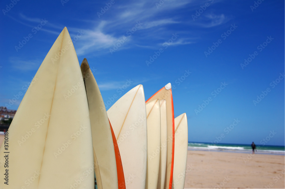 A rack of surfboards on a beach.