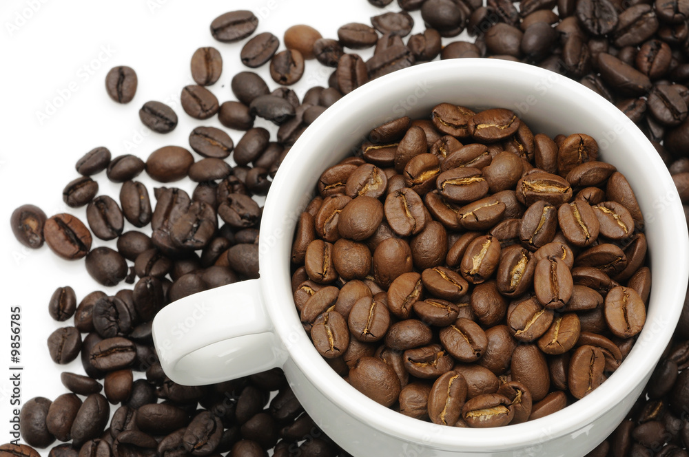 Cup of coffee beans over beans background with copyspace