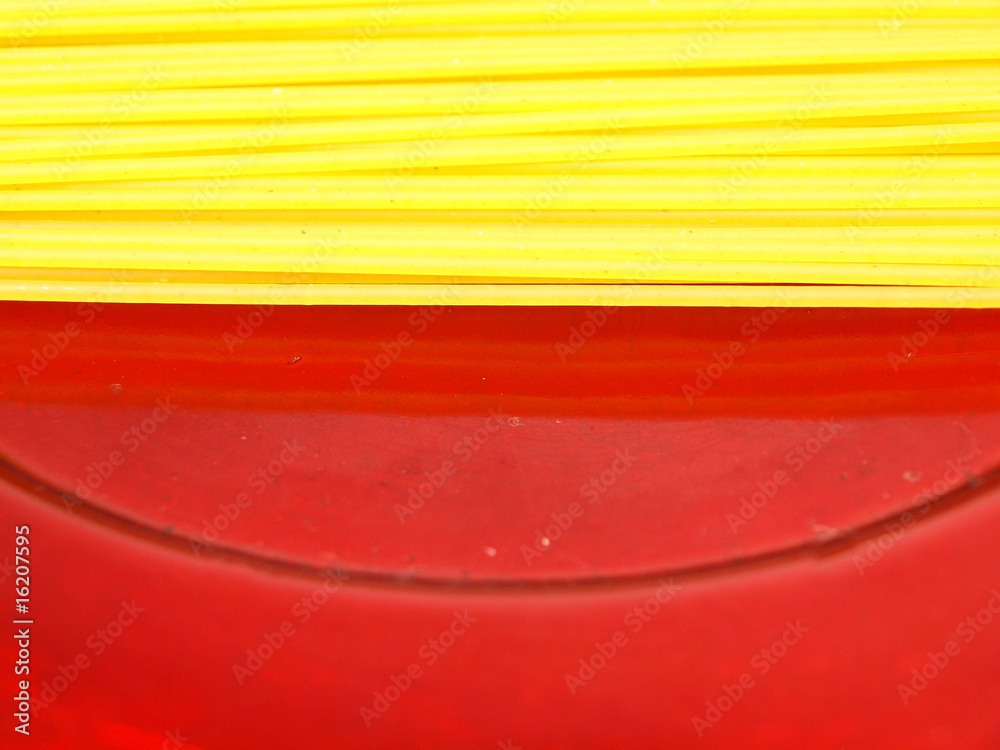 uncooked spaghetti served on red plate