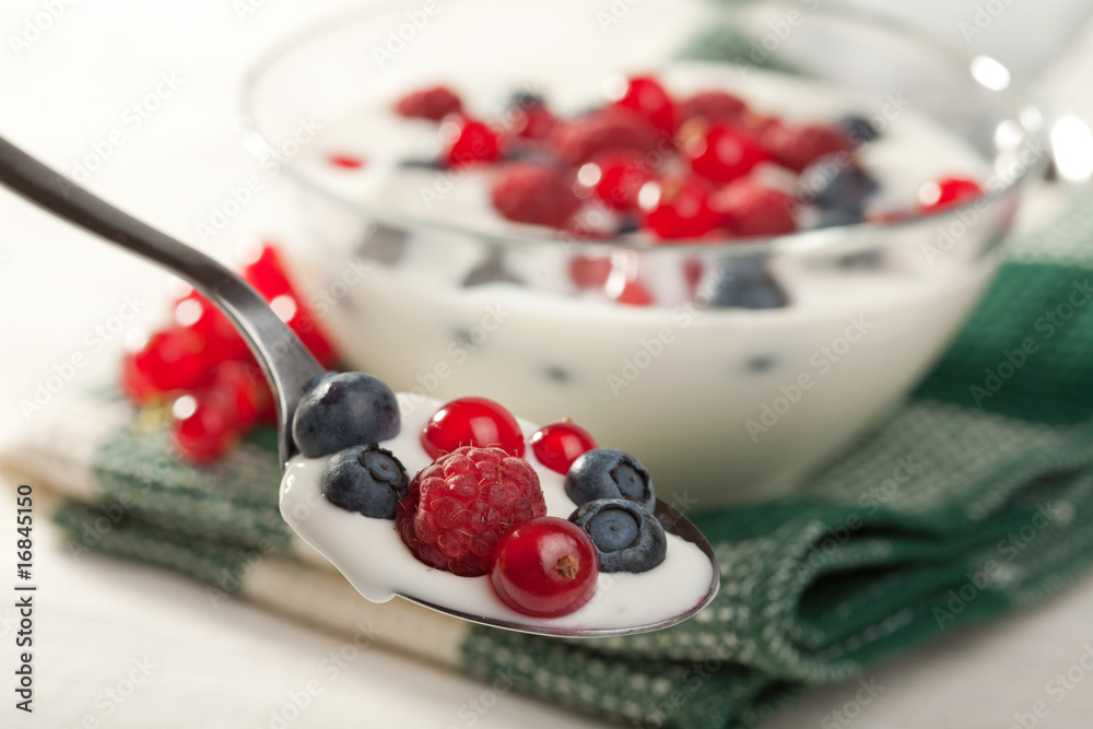 spoon with  yogurt and wild berries