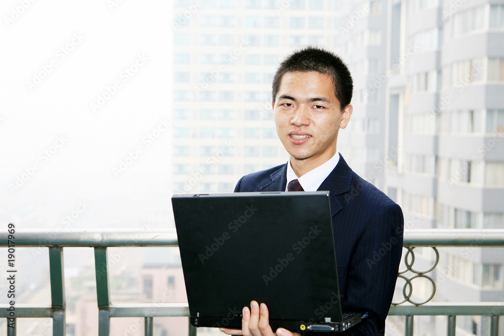 young asian businessman work with laptop on the balcony