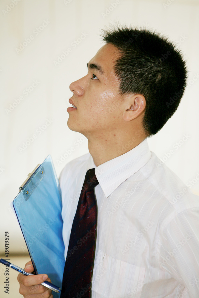 young asian businessman sitting on desk in office