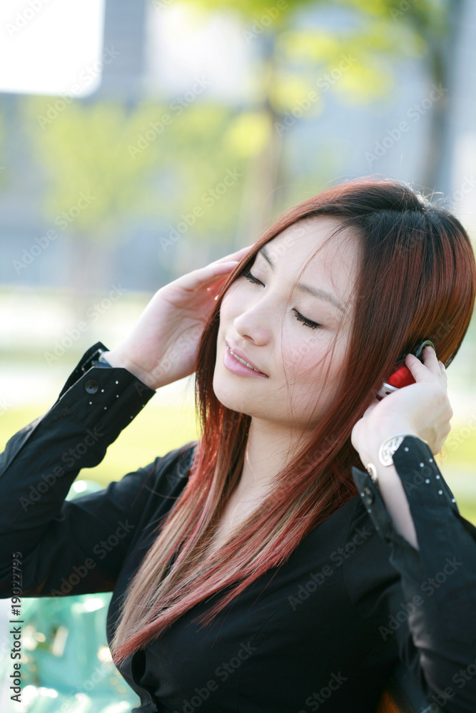 young beautiful asian listening to the music