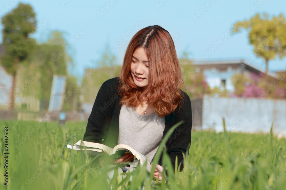 年轻的亚洲女孩在户外阅读