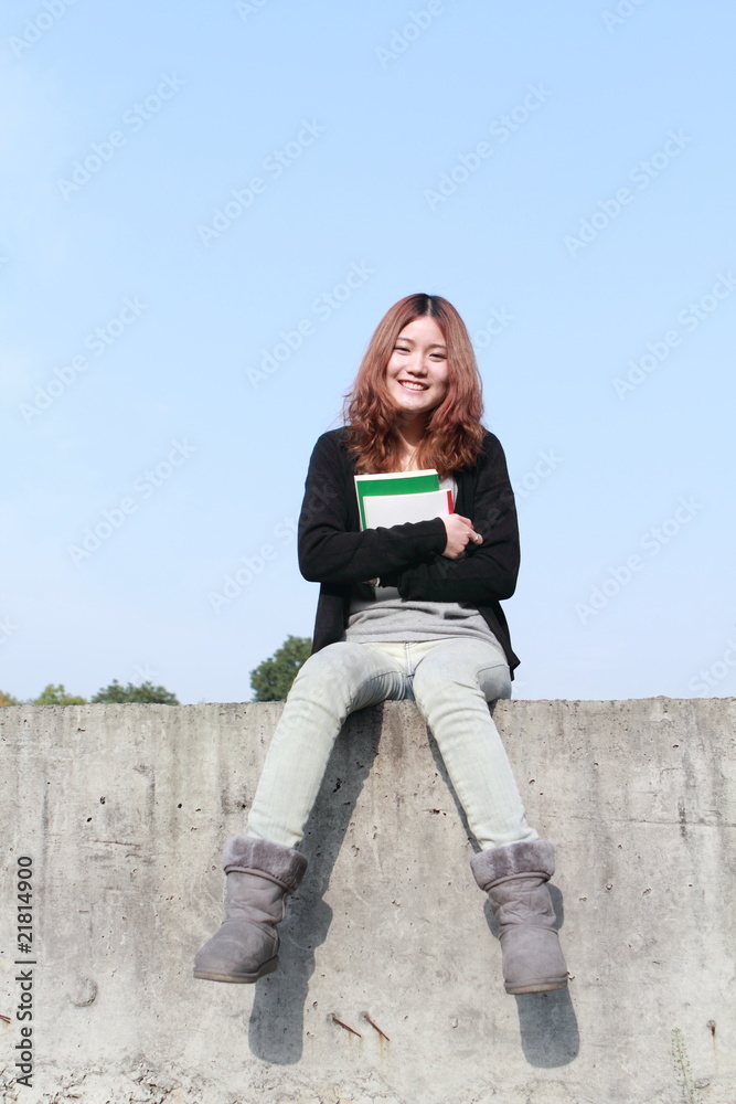 年轻的亚洲女孩在户外阅读