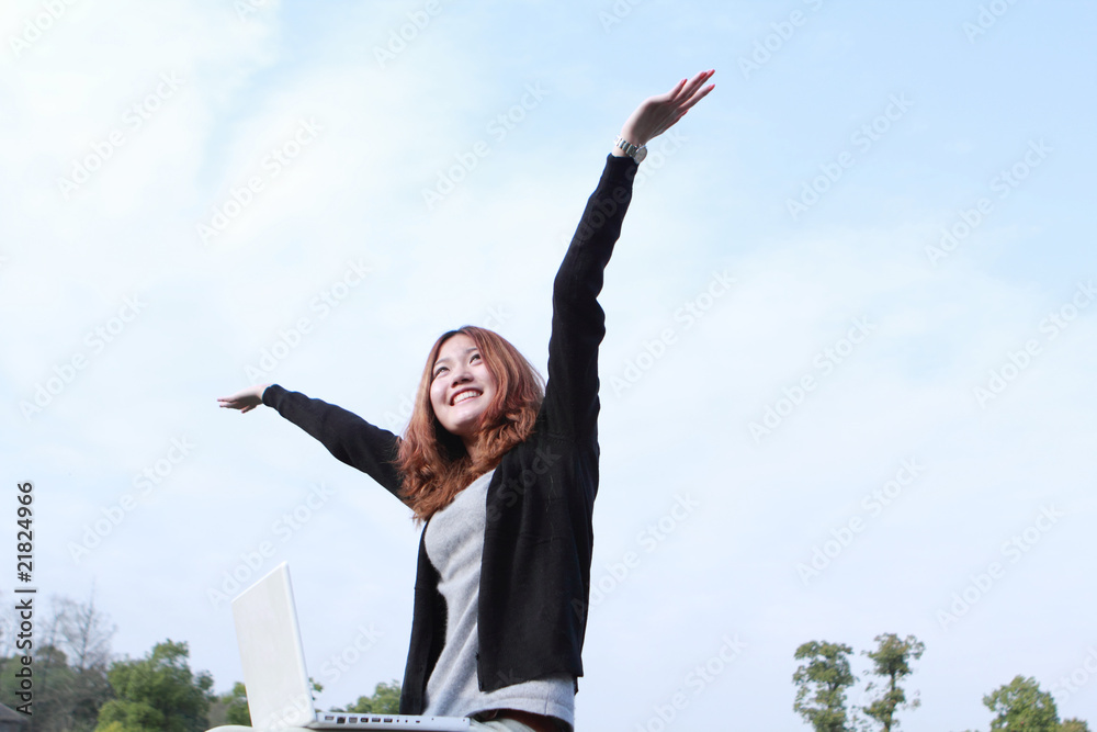 亚洲女孩与笔记本电脑户外