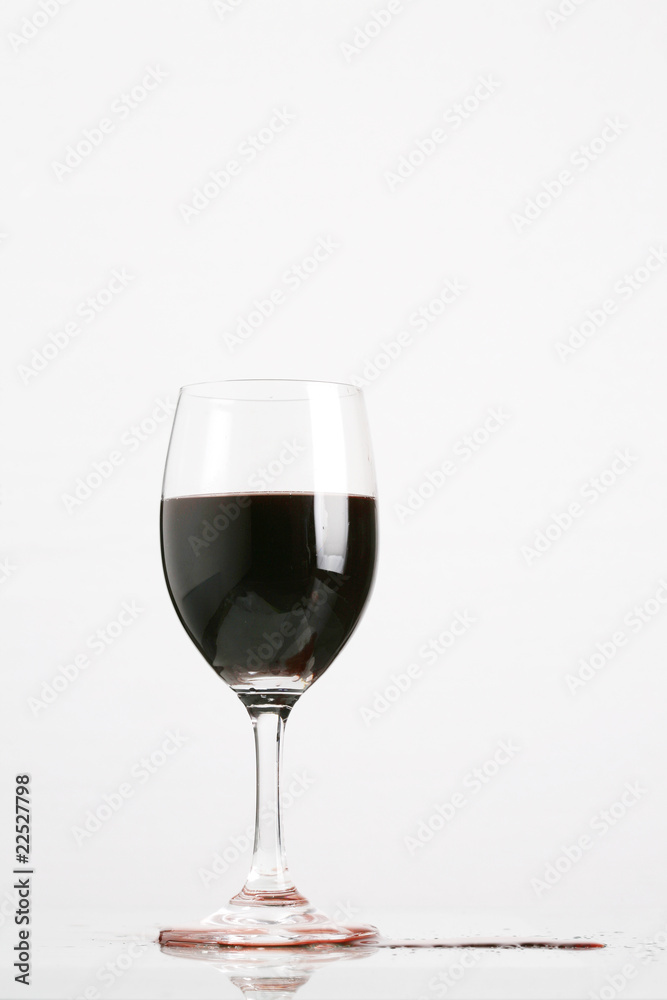 Red wine in wineglass isolated on white background ..