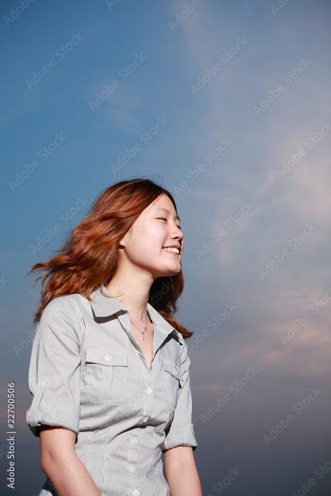 日落时海滩上美丽的年轻女子。