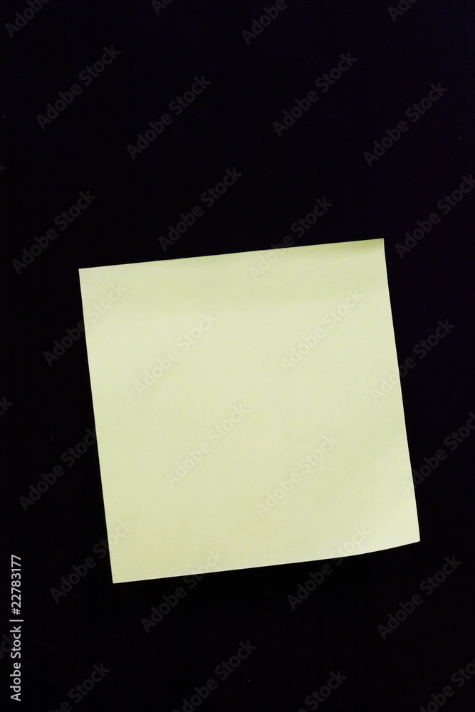 white sticky note with shade on black background