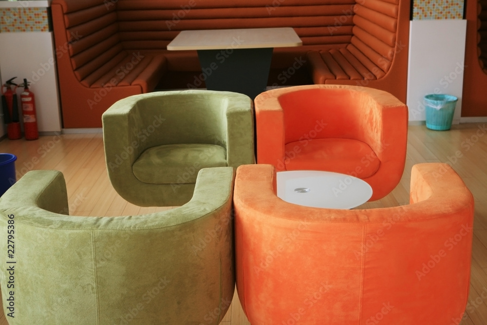 red and green sofa beside the table in the bar