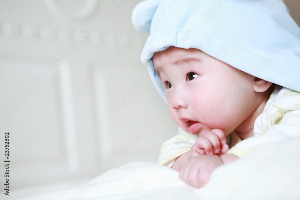 Cute little baby in bed, wearing a blue cartoon clothes