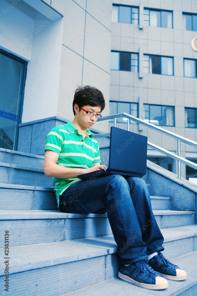 asian male student with laptop