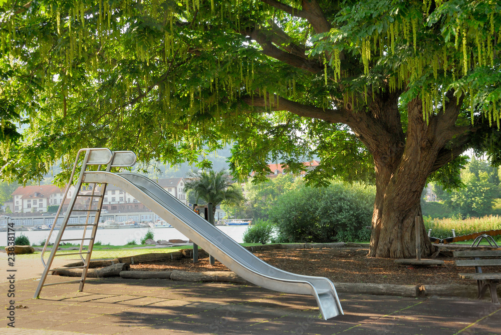 Park mit Rutsche und großem Baum