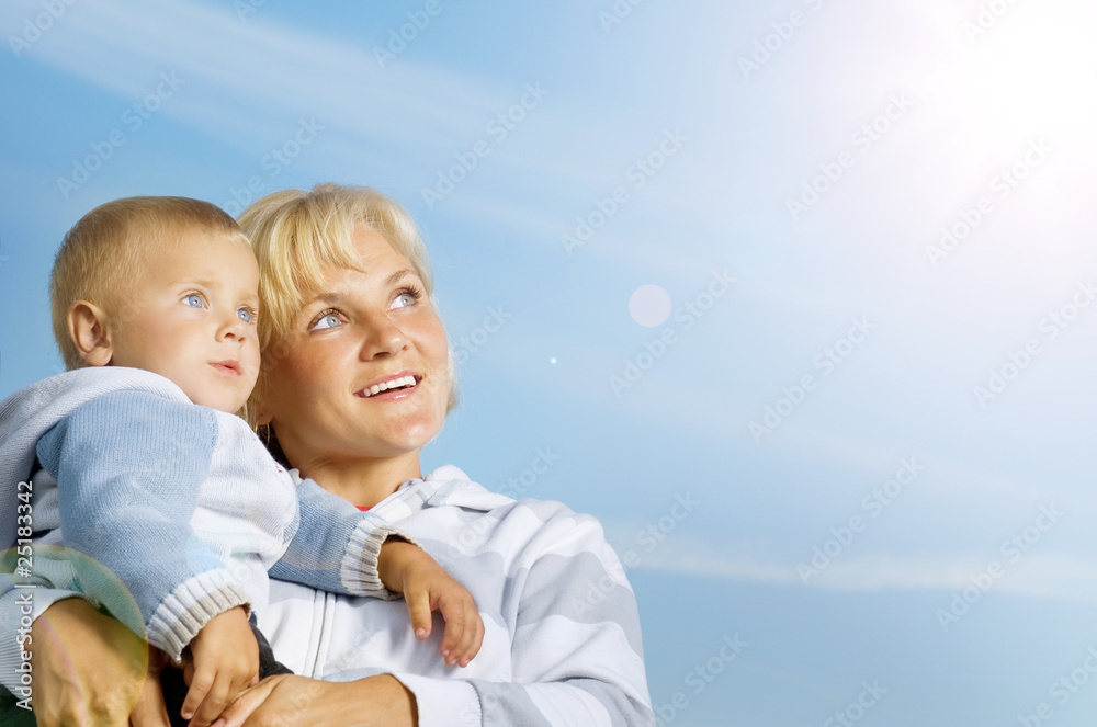 Happy Mother and Baby outdoor.Over Clear Blue Sky