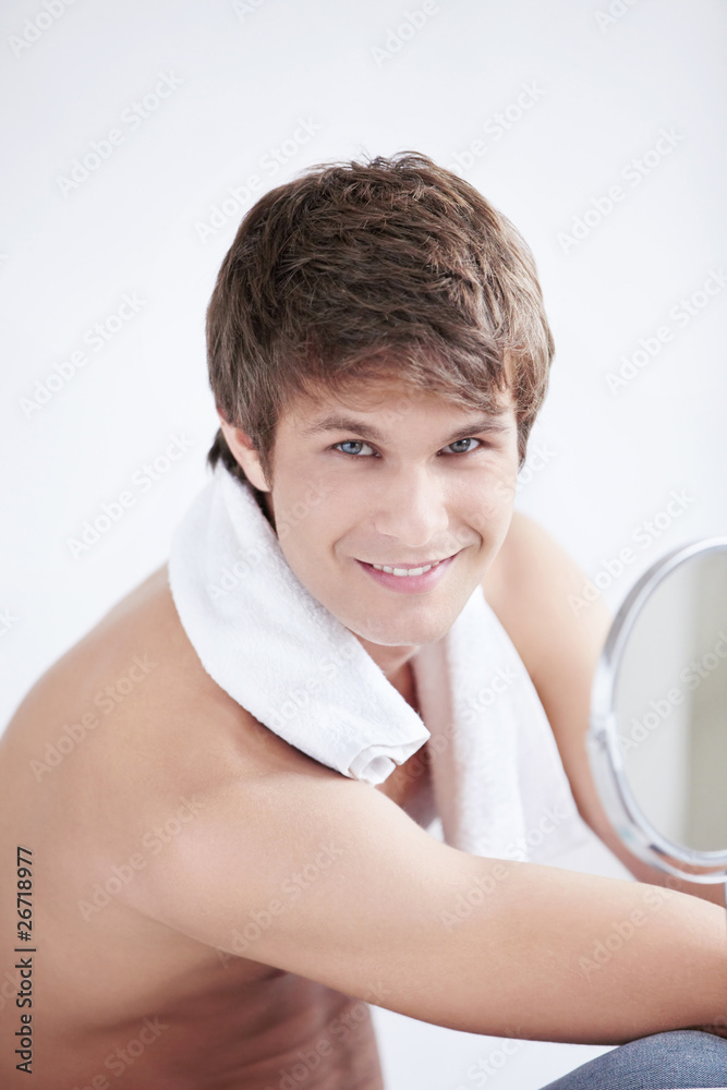 A young man with a towel in the mirror