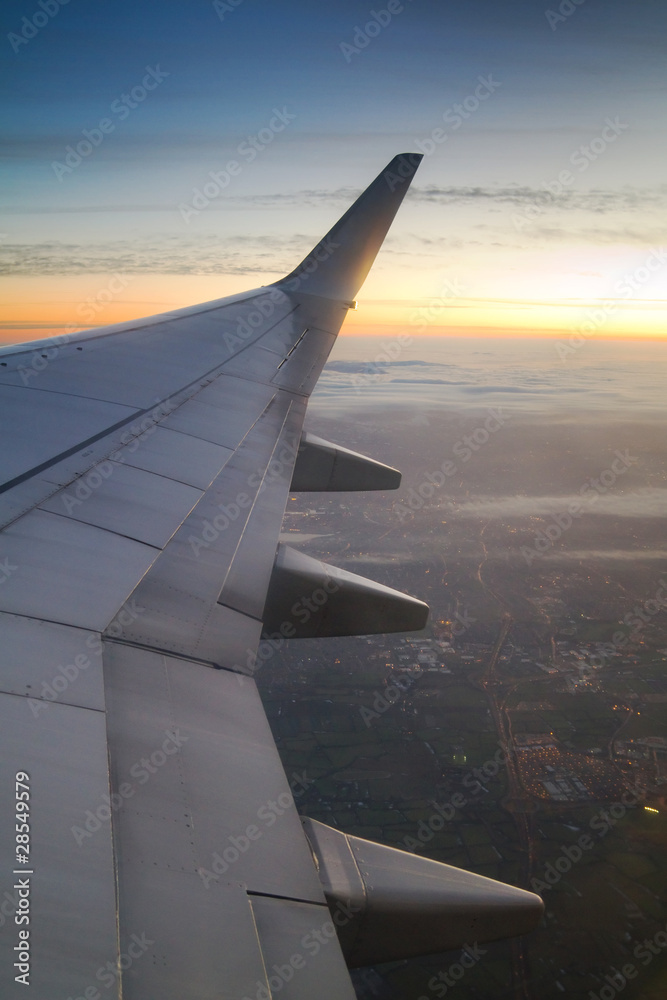 Wing of the plane with sky at sunset