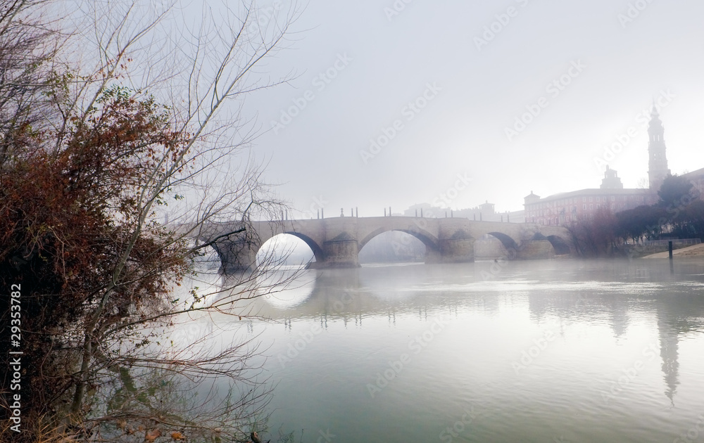 paisaje nublado con rio y puente