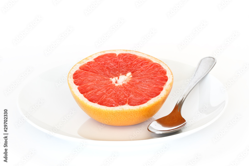 half grapefruit on plate with spoon