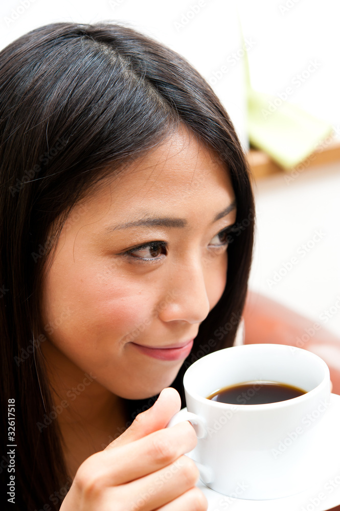 beautiful asian woman drinking a cup of coffee