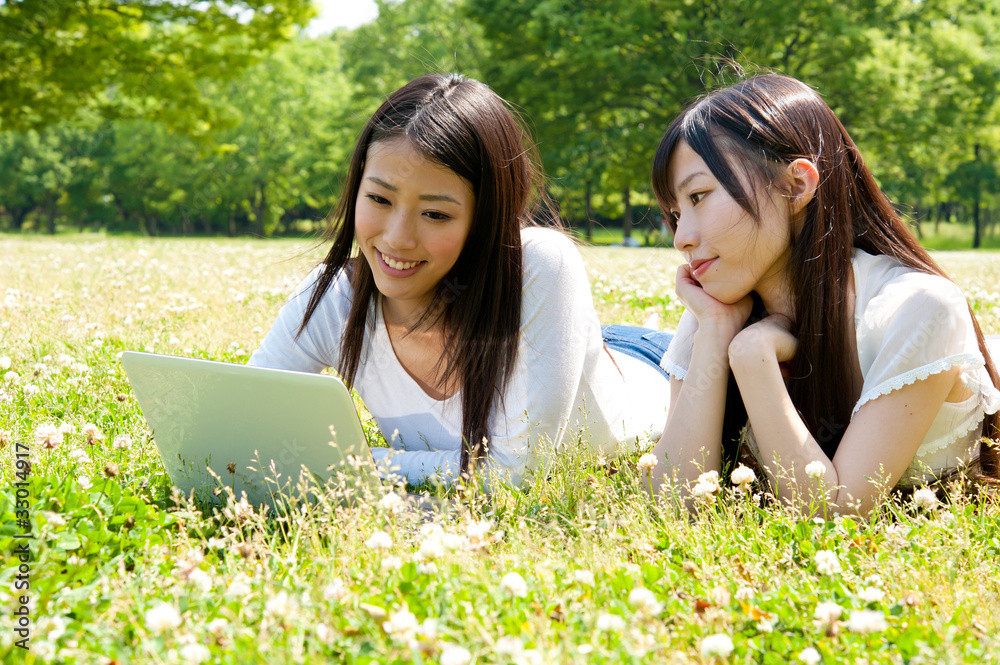 beautiful asian women using laptop in the park