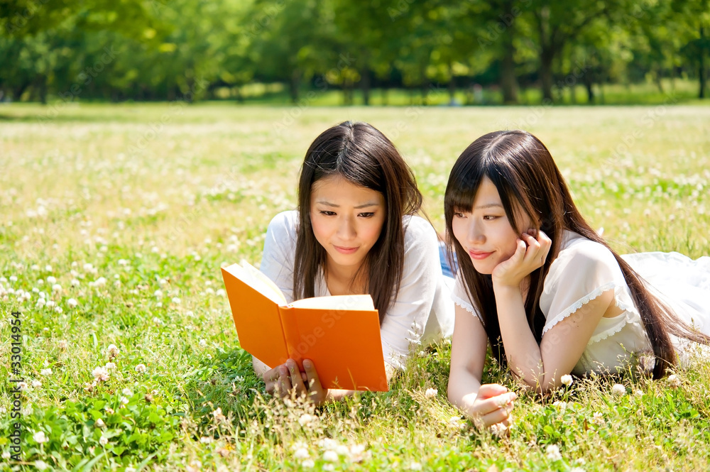 beautiful asian women reading a book in the park