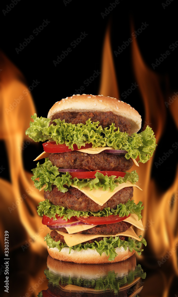 Hamburger with fire on black background