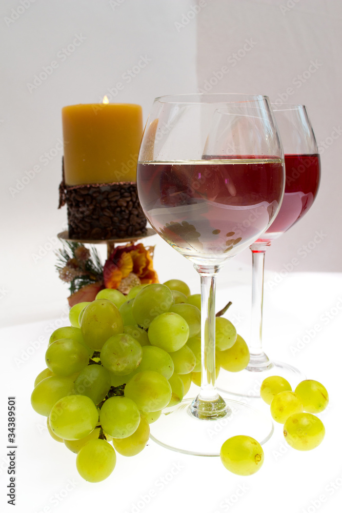 Glasses of white and rose wine and grapes over white