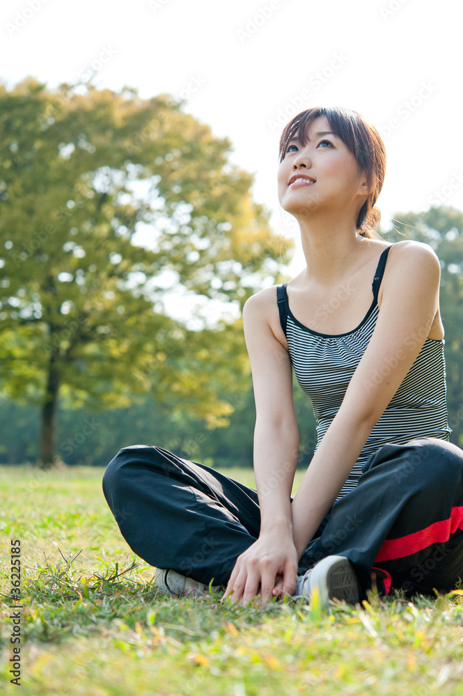 美丽的亚洲女人在公园放松