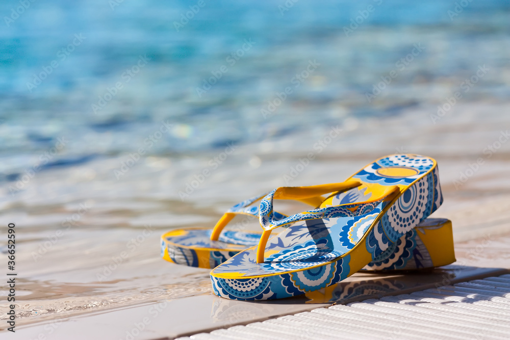 Bright flip-flops by a swimming pool