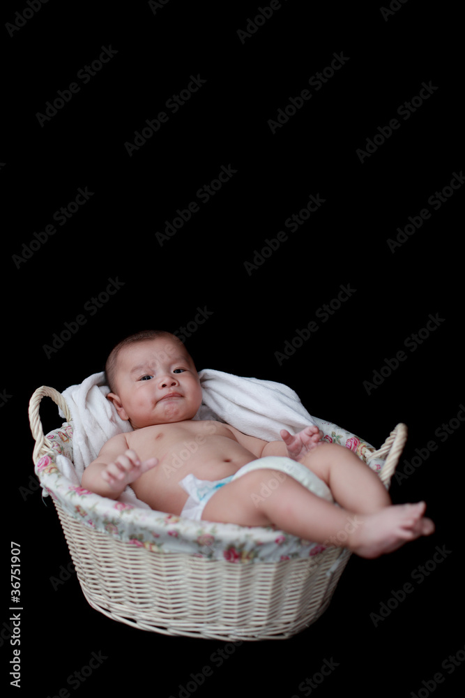 cute baby in  basket with black background