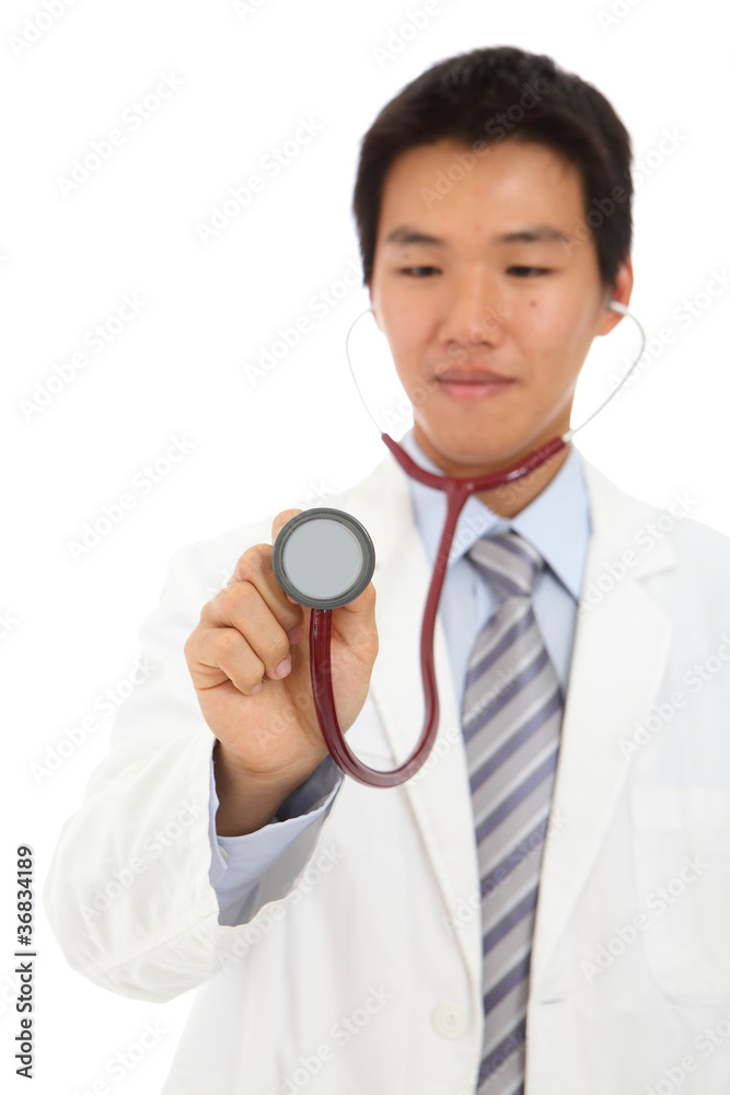 Young doctor listening with stethoscope