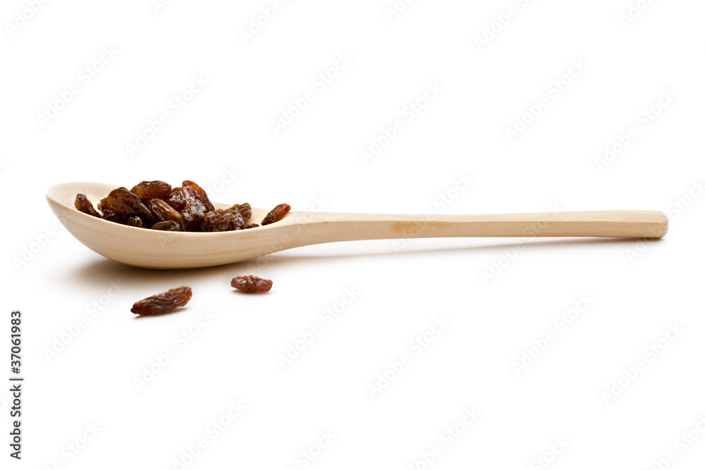 Raisins in a spoon on the white background