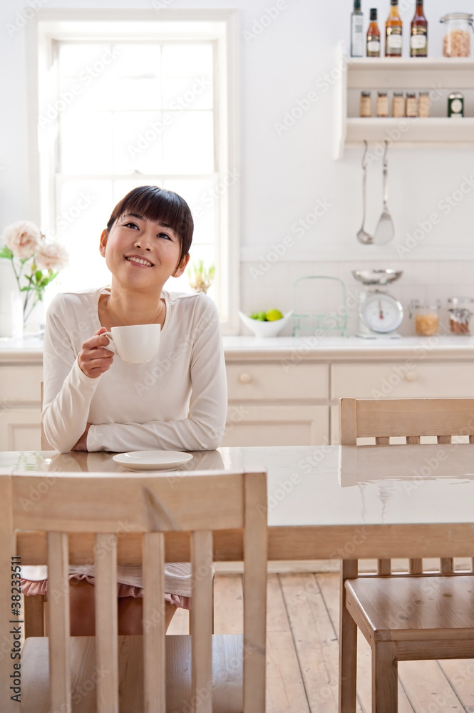 迷人的亚洲女人在厨房放松