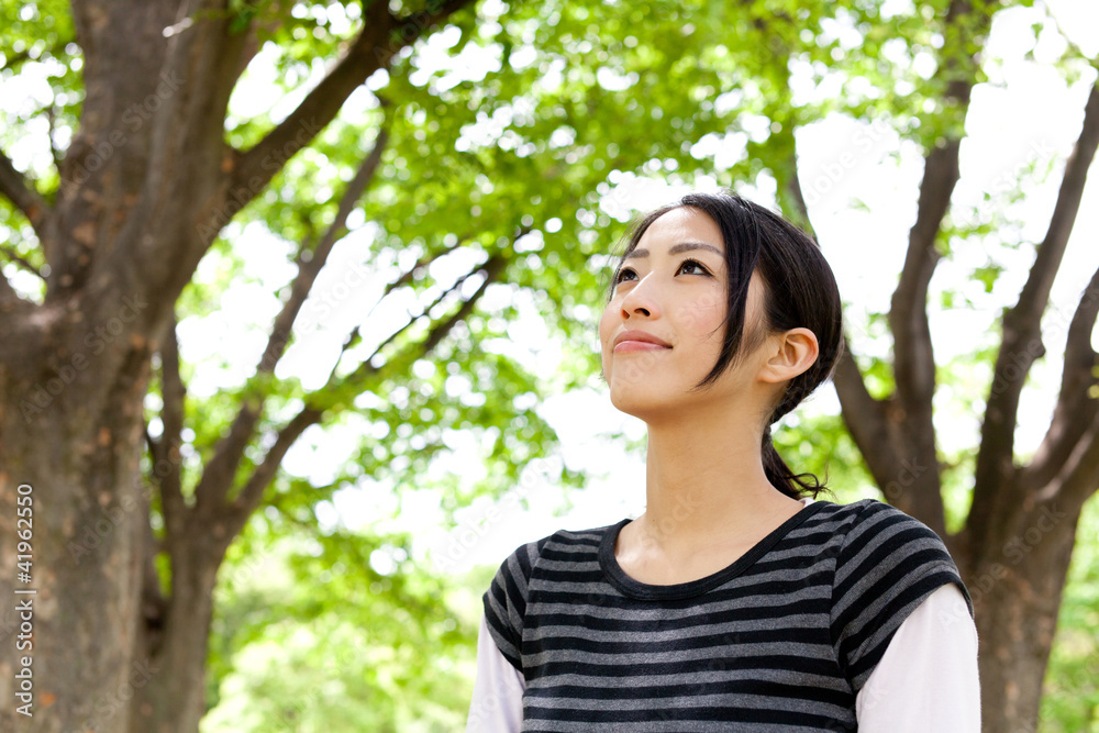 年轻的亚洲女人在森林里放松