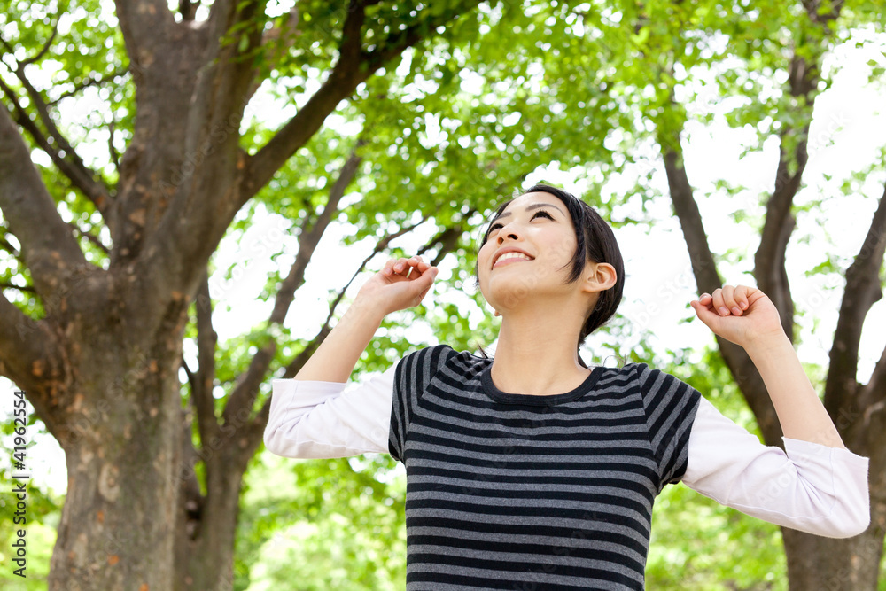 年轻的亚洲女人在森林里放松