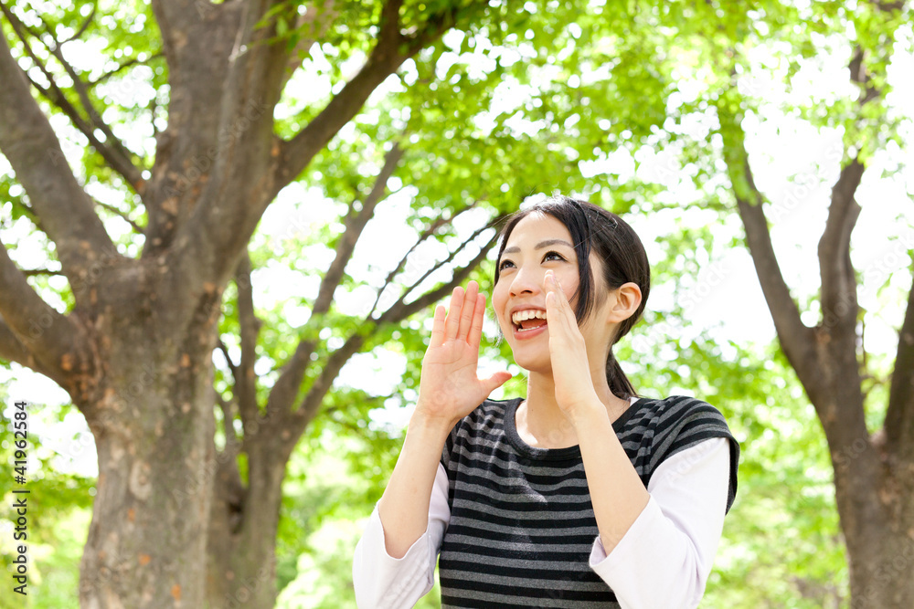 年轻的亚洲女人在森林里欢呼