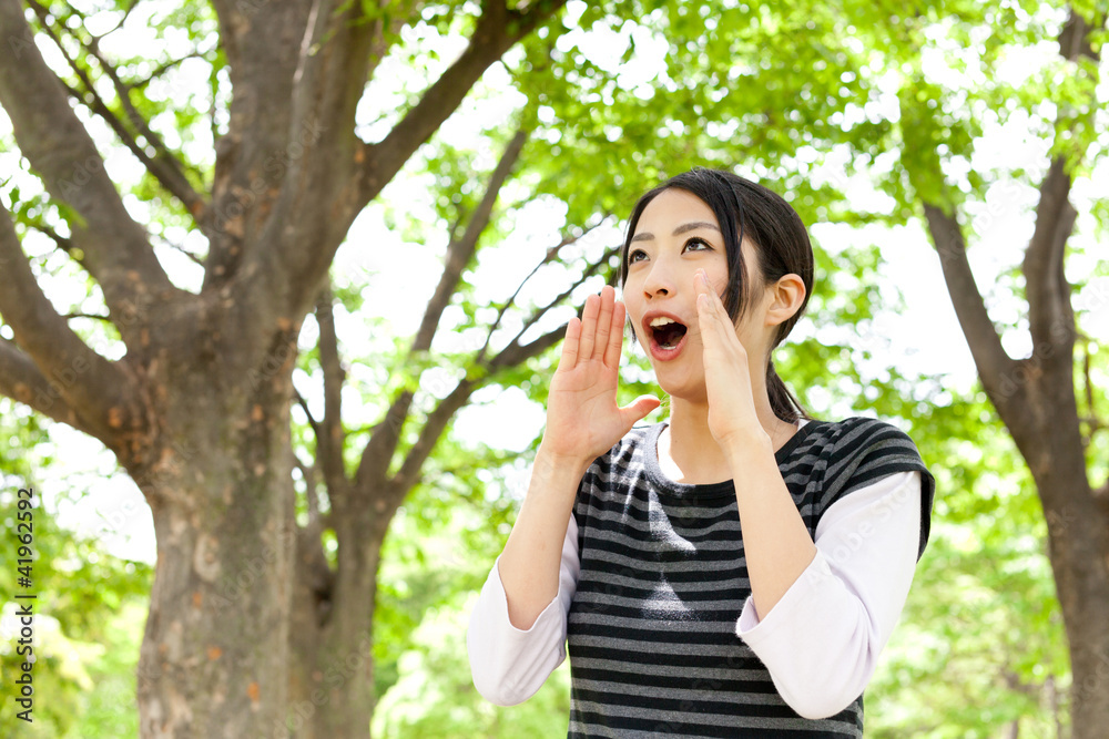 年轻的亚洲女人在森林里欢呼