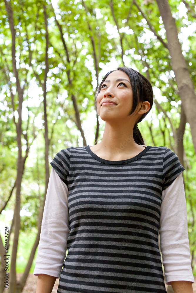 young asian woman relaxing in the  forest