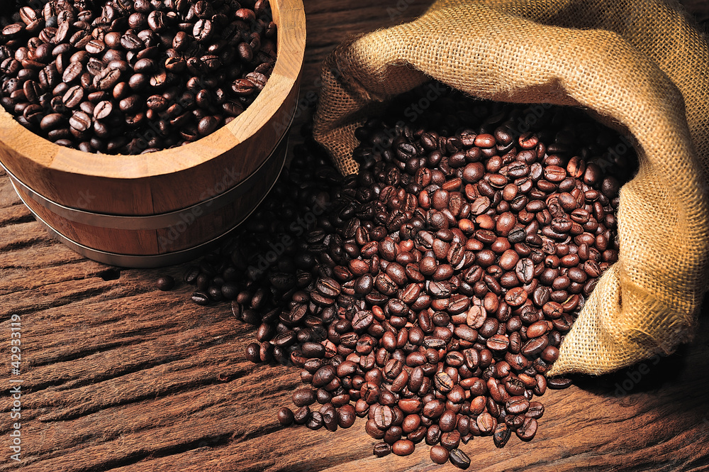 Coffee beans in burlap sack and wooden bucket