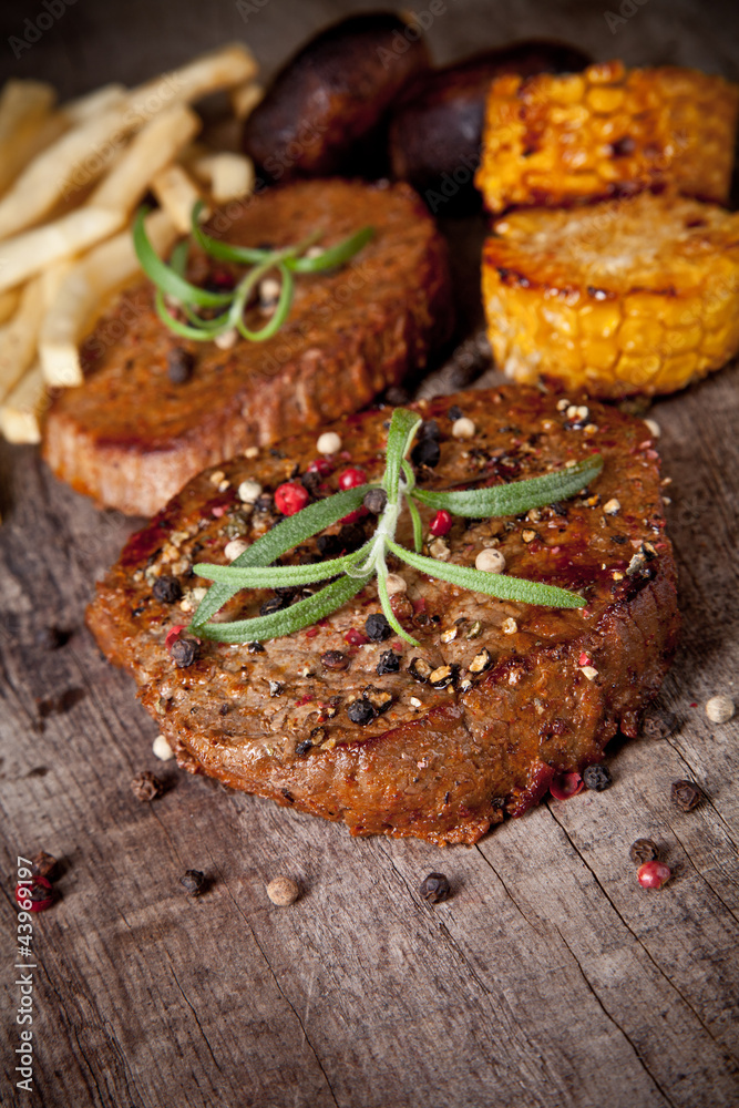 Delicious beef steaks on wooden table