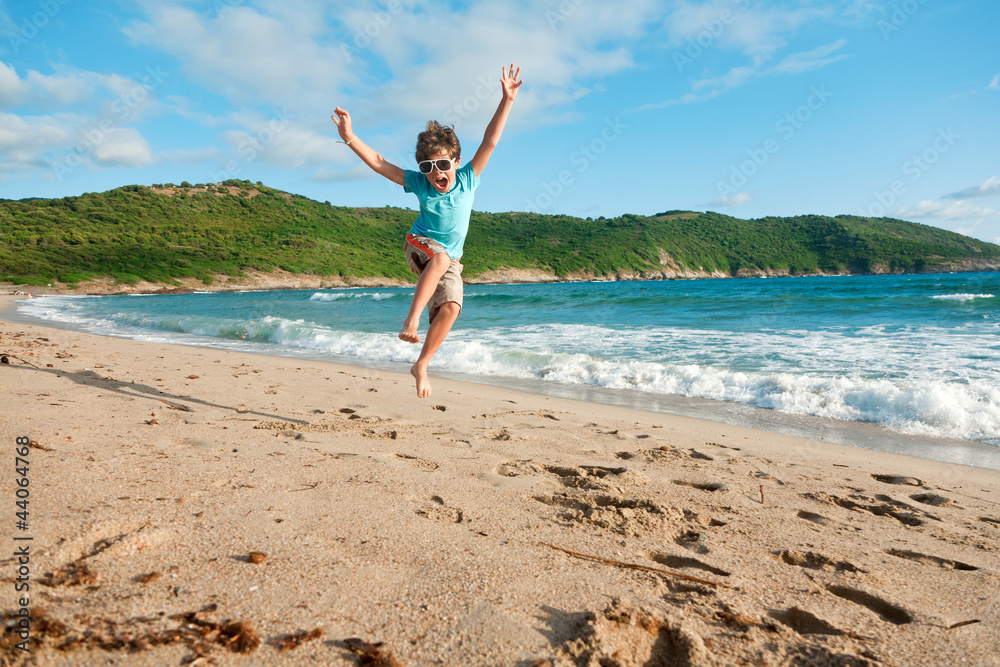 young boy jump in the sea