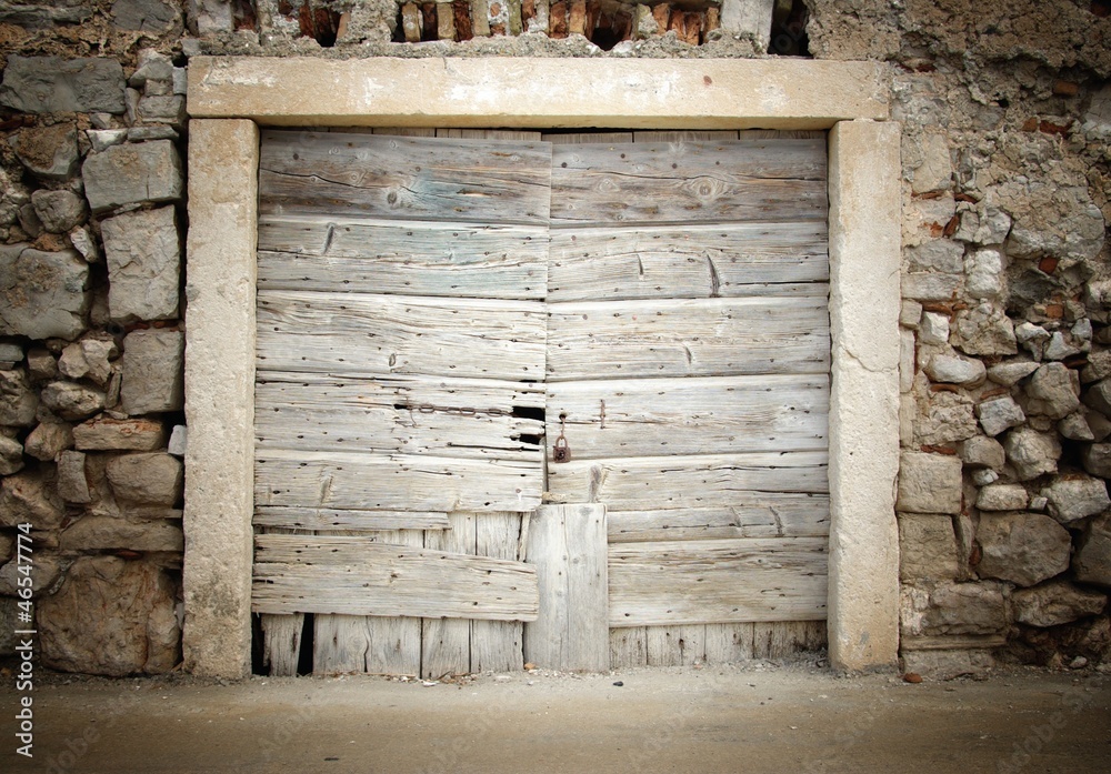 Old wooden door in stone house