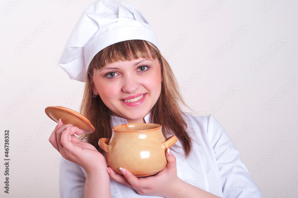 young woman chef holds a pot of cooked food