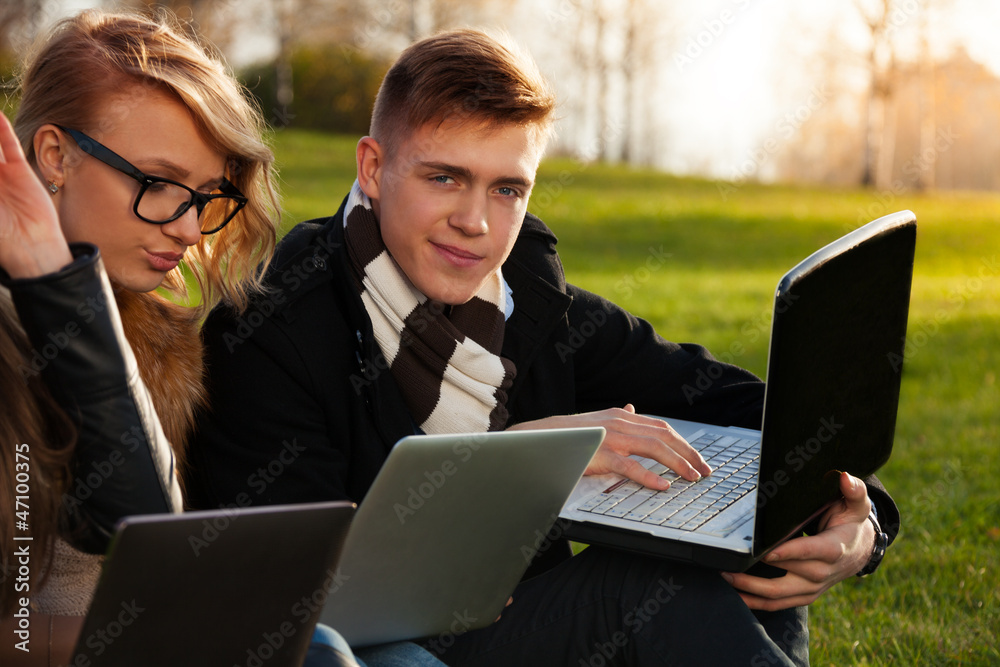 Students, boy and girl browsing in sunny park