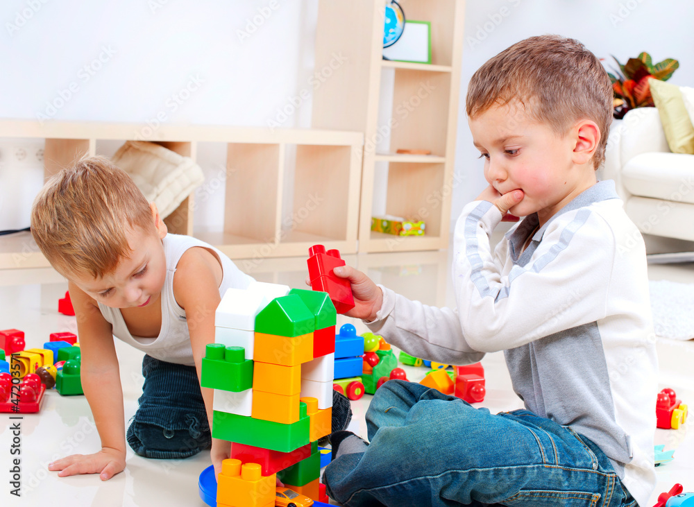 Children Boys playing with construction set on the floor