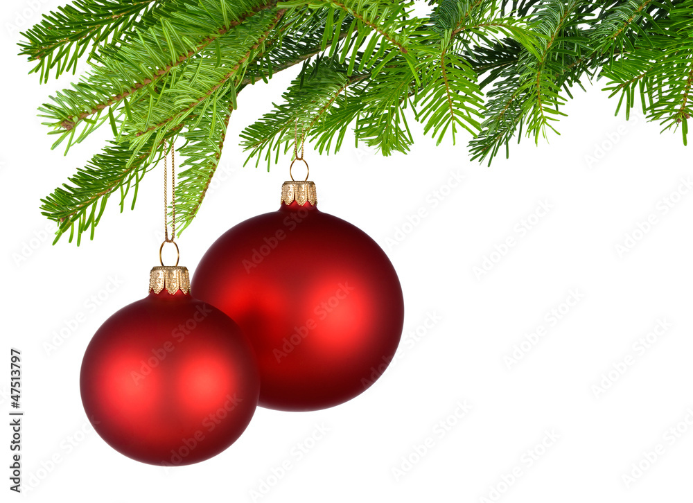 Zwei rote Christbaumkugeln hängen am Tannenzweig