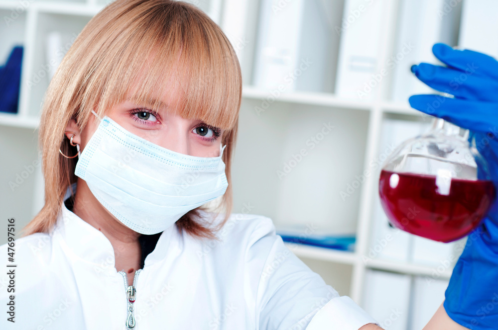 Chemist woman holding a test tube with red liquid