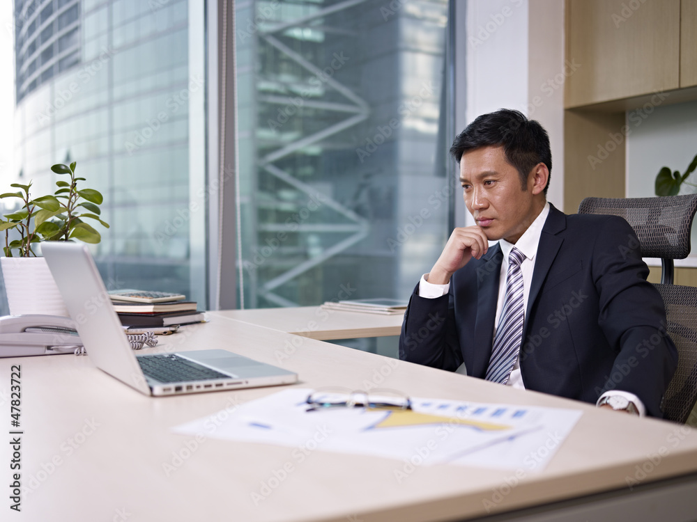 asian businessman thinking in office