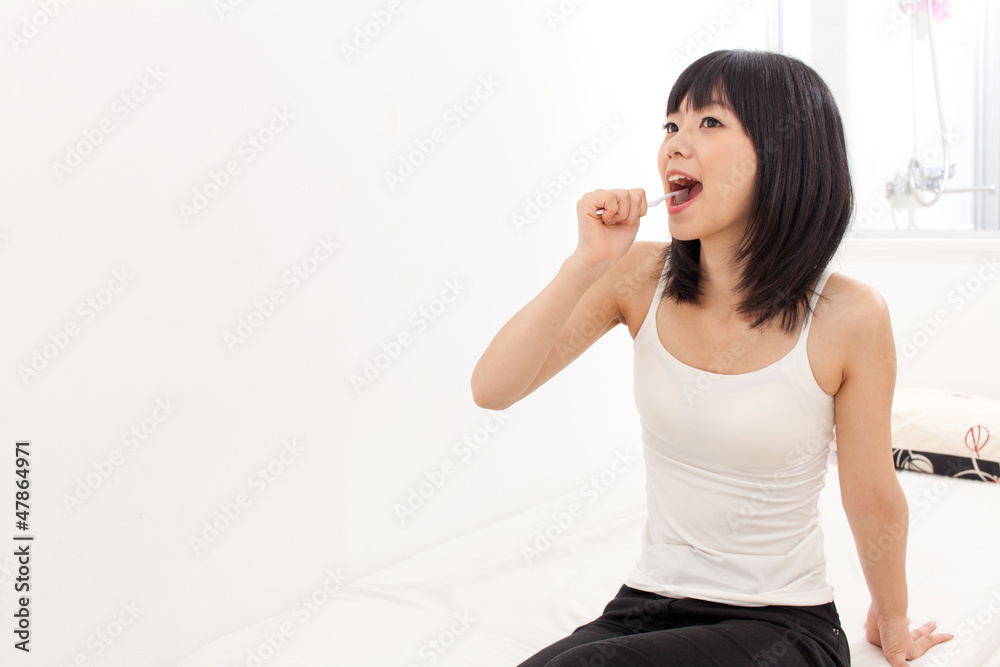 attractive asian woman blushing her teeth