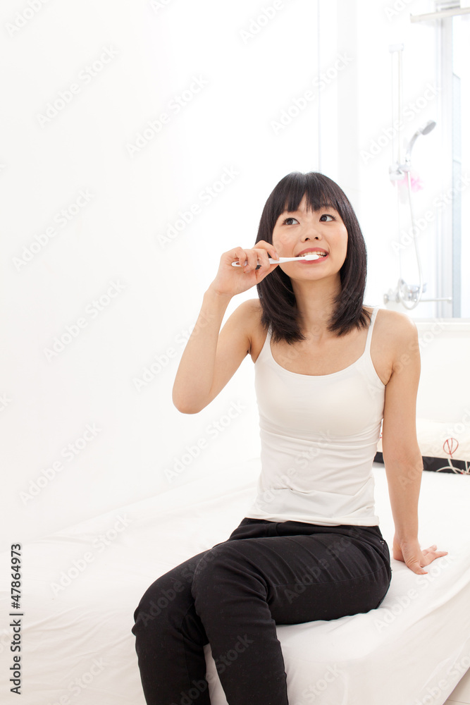 attractive asian woman blushing her teeth